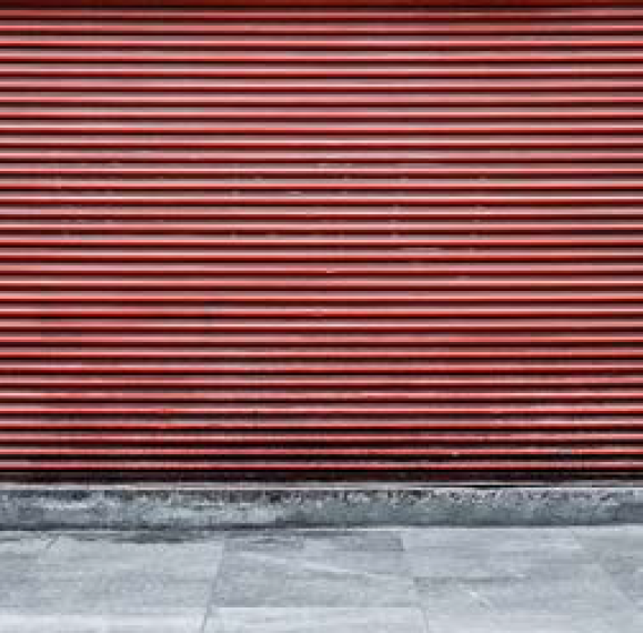 Industriële rode rolluiken met een robuuste en stedelijke uitstraling.